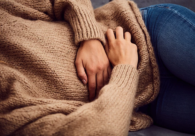 Frau mit Magenschmerzen Blähbauch kann zu Magenschmerzen führen